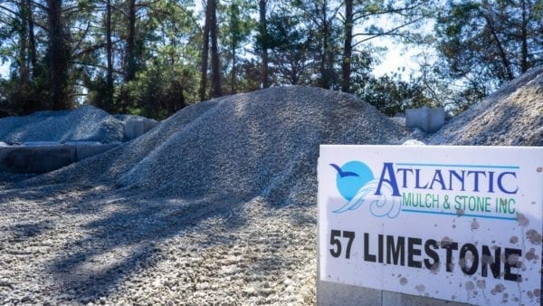 mound of 57 limestone with Atlantic Mulch & Stone sign on right