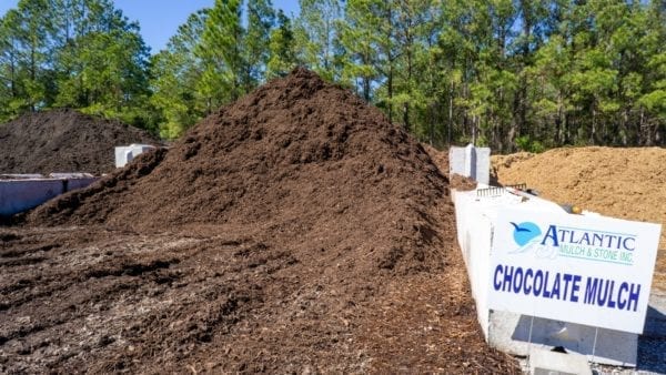 mound of chocolate mulch with Atlantic Mulch & Stone sign on the right