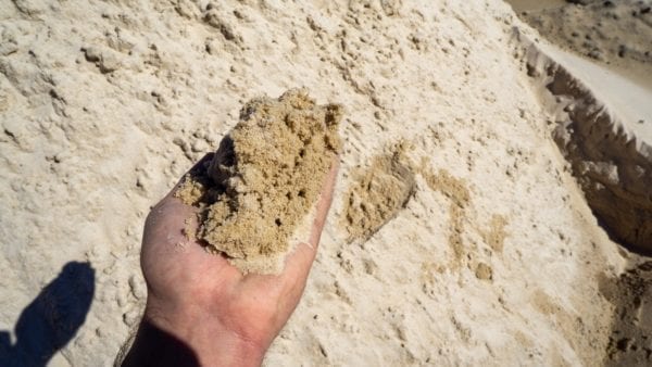 mortar sand in hand for scale and detail